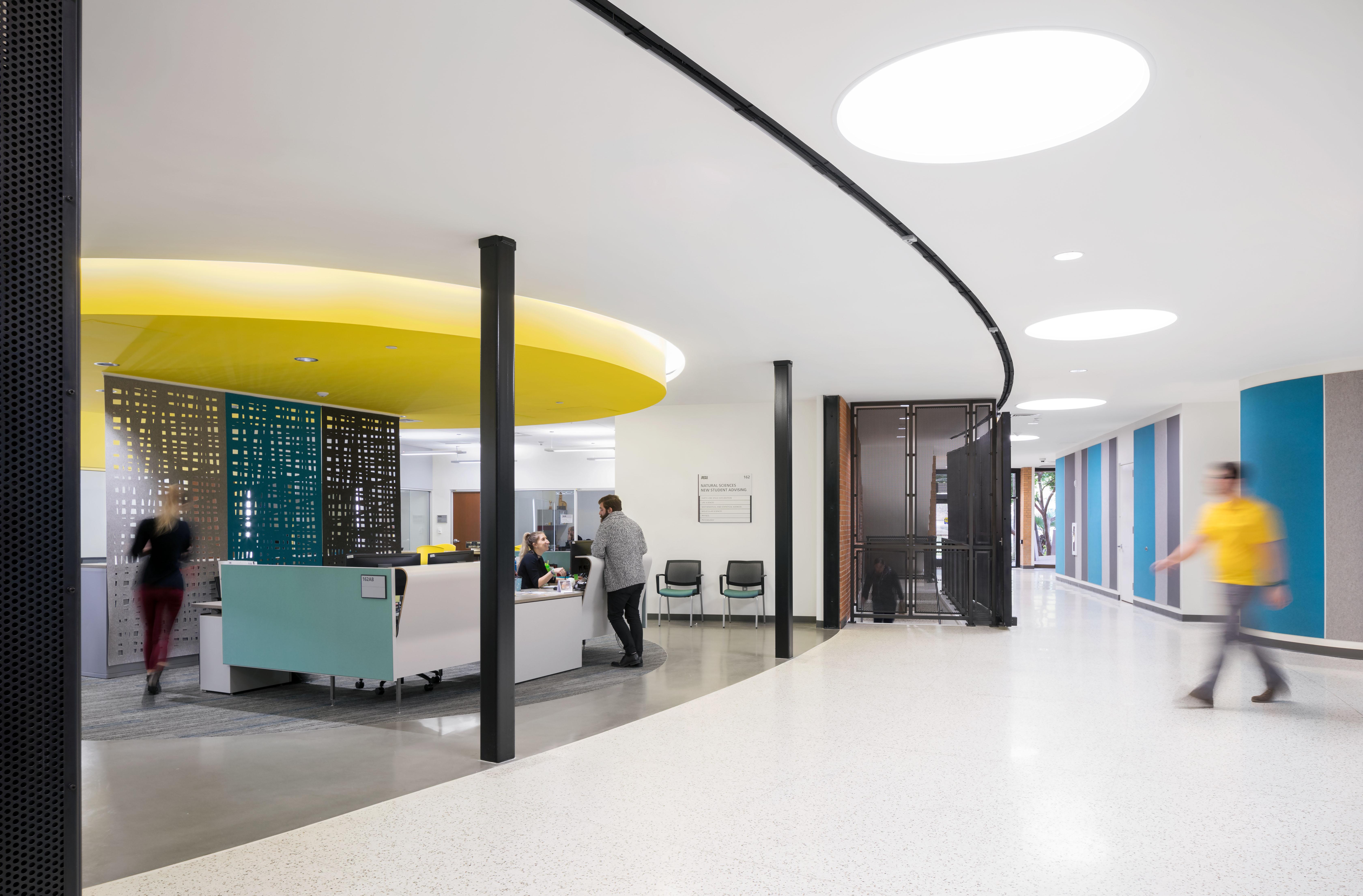 A few people inside Armstrong Hall with colorful walls