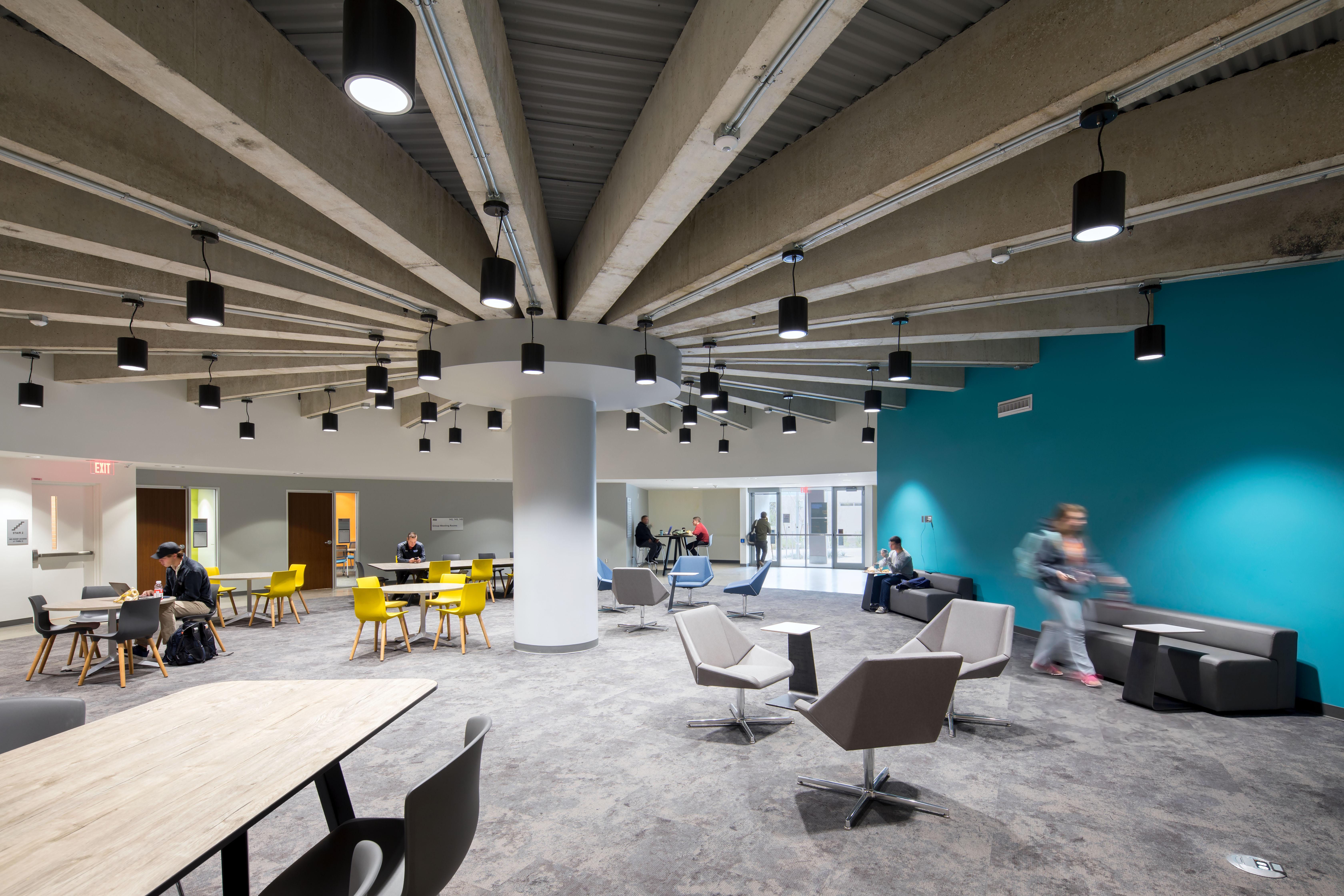 Students inside Armstrong Hall with hanging lights and turquoise wall